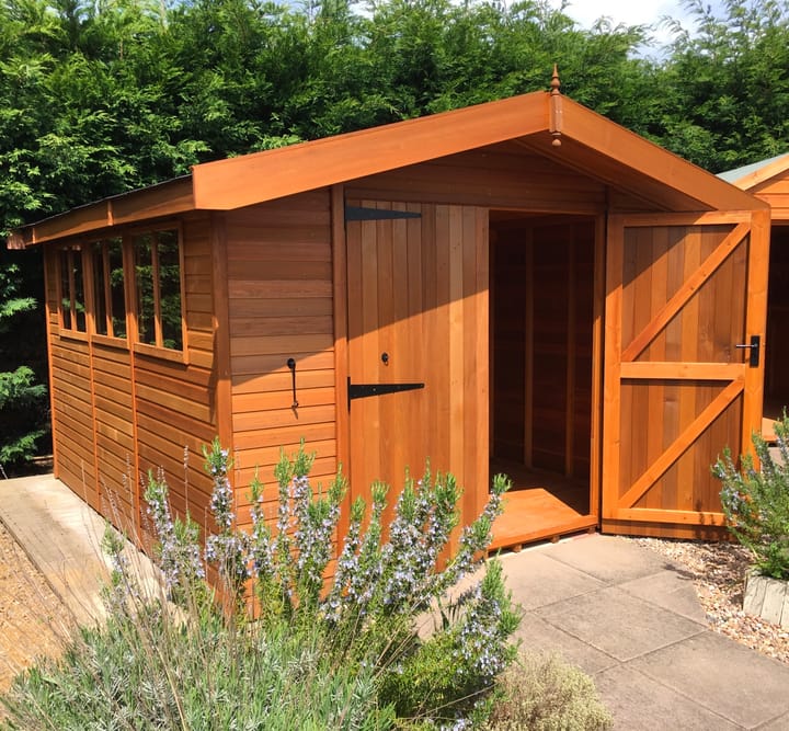 This 10ft x 12ft Malvern Heavy Duty Apex is constructed with cedar cladding. Optional upgrades as shown include; double doors and a black felt tiled roof.