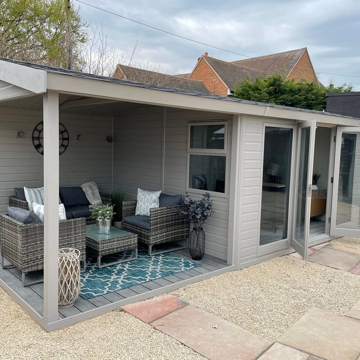 This 12ft x 10ft Studio Pavilion illustrates how the available extensions can transform your building into a multi-purpose garden room.

A 4ft wide shed extension has been added to the right hand side, perfect for storing all your garden tools.

An 8ft wide open area extension has been added to the left hand side. This creates a cosy outdoor seating area, which can accommodate a patio set.....as you can see!

The 12ft x 10ft office area provides plenty of comfortable working space. The overall size of the building with the added extensions is 24ft x 10ft. Other optional extras added include; a painted finish in Fleet Grey, black felt roof tiles, tinted windows, laminate flooring and painted mdf lining and insulation.