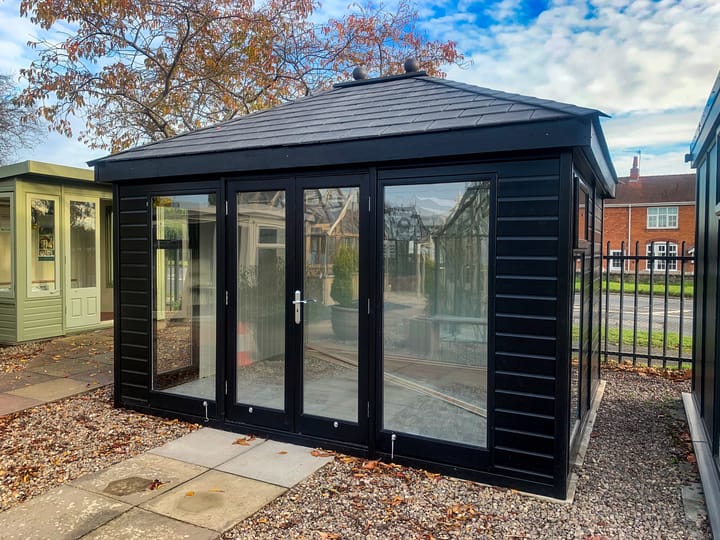 12ft x 10ft Malvern Studio Hipped painted in Black optional painted finish, with optional painted mdf lining and insulation, a deluxe laminate floor and slate effect tiled roof.