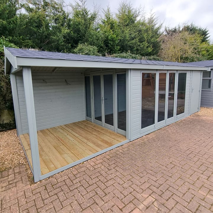 12ft wide x 8ft Deep Malvern Studio Pavilion. Shown here with optional upgrades such as Black Felt tiles, 8ft open area to the left, 4ft shed extension to the right, tinted glass, additional double doors opening onto the open area, Painted finish (Olive Grey), Laminate flooring and Painted internal MDF Lining and insulation. 