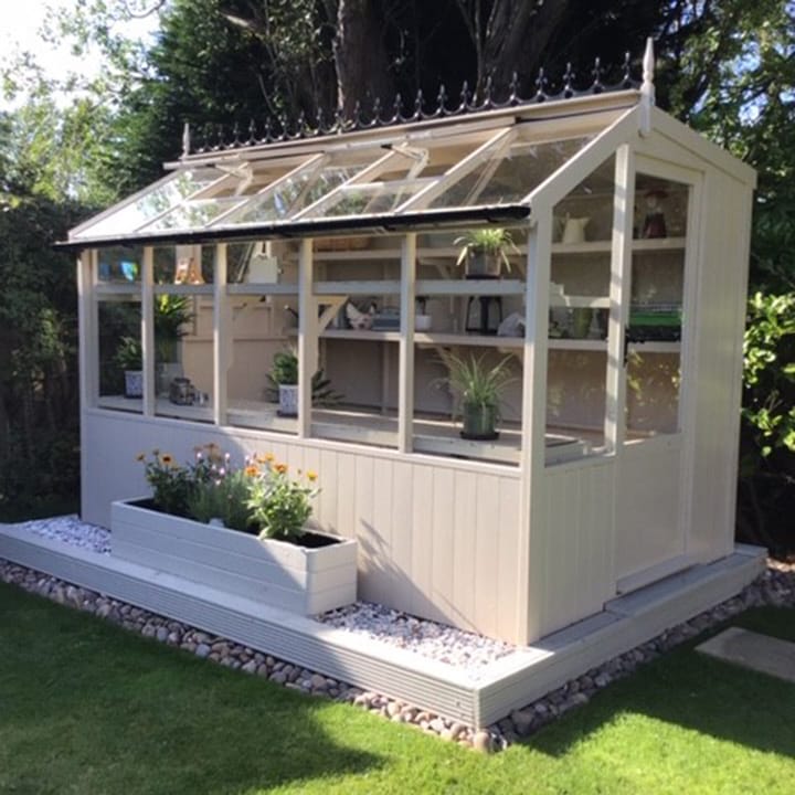 This 6ft x 10ft Swallow Jay greenhouse has the optional 'Oxford Stone' painted finish. Optional additional high level shelving and guttering have been added to this greenhouse.