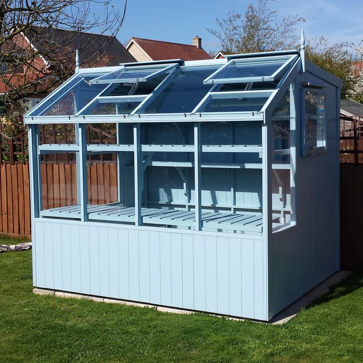 This 6ft x 8ft Swallow Jay greenhouse has the optional 'Lulworth Blue' painted finish. Optional additional high level shelving has been added to this greenhouse.