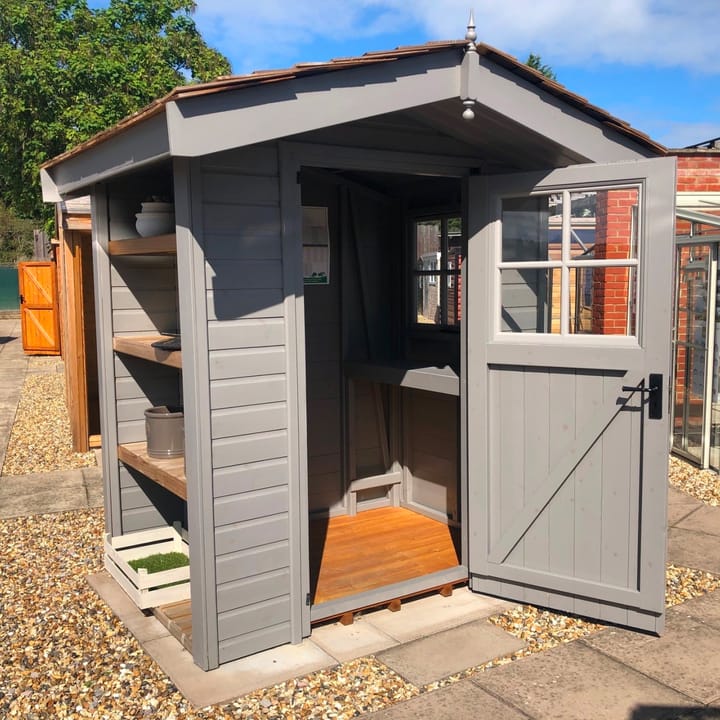 At 6ft x 4ft this Heavy Duty Apex is the smallest size we offer, but as you can see from the photo, it has been packed with many optional extras.

The heavy duty redwood cladding has had the optional painted finish in 'Urban Grey', Georgian window upgrade, Georgian window positioned in the door, 3 external shelves to length, a cedar shingle roof and a workbench under the window!