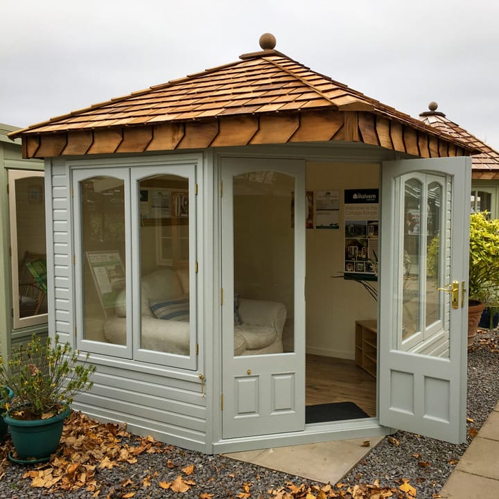 This 8ft x 8ft Clifton in Dove Grey looks absolutely stunning. The 'cottage' style arched windows really add a decorative touch. Brass has been chosen for the door and window furniture. 

One point worth knowing: If you opt for the double glazing upgrade, the arched top of the windows become square to accommodate the double glazed units.