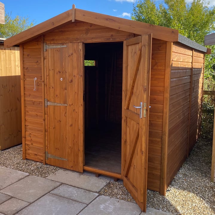 This 8ft x 10ft Heavy Duty Apex is constructed in heavy duty redwood cladding. A roof overhang and a choice of opening windows or security windows are standard features. Ironmongery is available in a choice of black or as pictured here chrome. Optional double doors have been added.