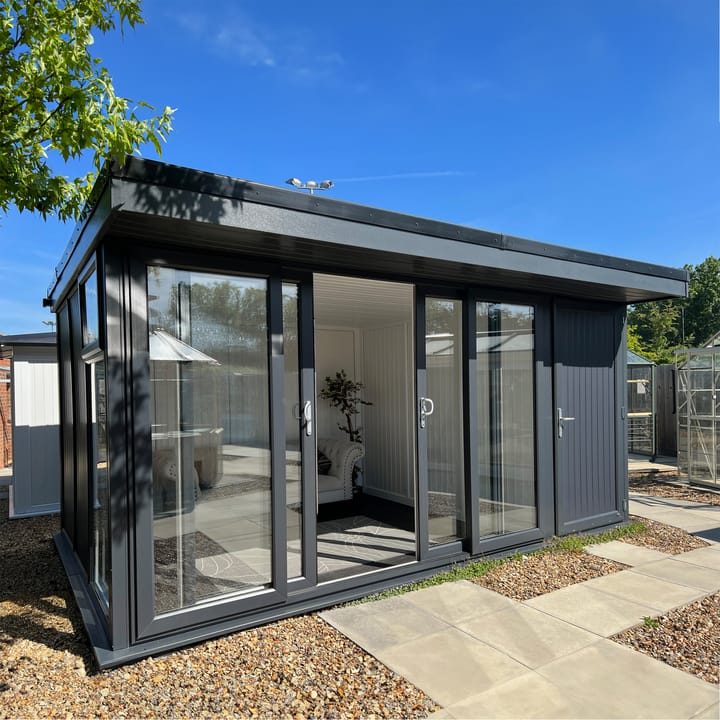 Nordic Broadway Flat 3.6m x 3m in Grey. The Broadway Flat includes large double sliding doors to the front. A glass to ground window with a top opening vent is positioned in each end, towards the front. The fully glazed front of the building allows plenty of natural light without obscuring the view. 

This image also features the optional 4ft shed extension and optional vinyl flooring.