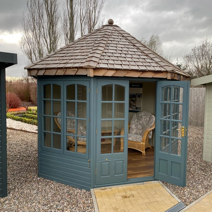 This 10ft x 10ft Malvern Hopton summerhouse has the optional painted finish applied in Ocean Blue. Also featured is the optional Georgian window upgrade, cedar shingle roof, painted mdf lining & insulation, brass upgrade and laminate floor.