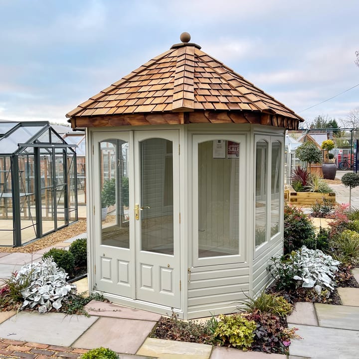 Cedar cladding has been chosen for this 7ft 7in x 7ft 7in Malvern Hopton summerhouse. Also featured in this photo is the optional laminate floor upgrade, cedar shingle roof, painted finish, painted mdf lining & insulation, Brass upgrade
