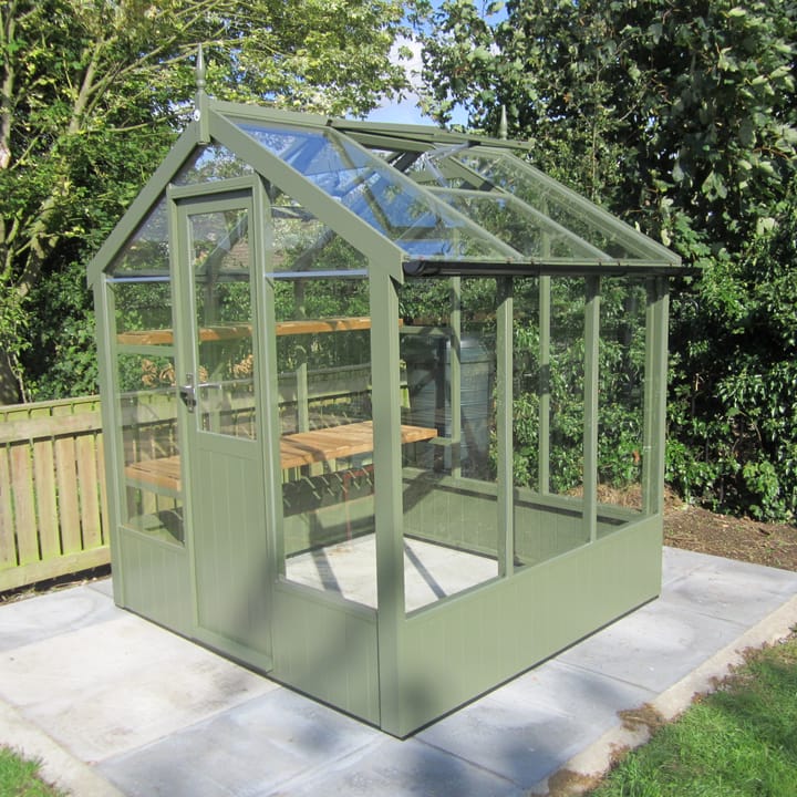 This 6ft x 6ft Kingfisher greenhouse is manufactured from Thermowood. Optional 'Bracken' painted finish has been applied. Staging to one side and automatic roof vents are a standard feature.Optional high level shelving and guttering has been added to this greenhouse