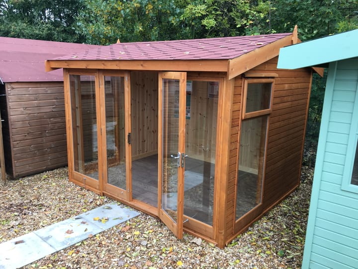 10ft x 8ft Malvern Studio Pavilion in standard Redwood cladding. Optional upgrades include a red felt tiled roof, tongue and groove lining and insulation and a deluxe laminate floor.