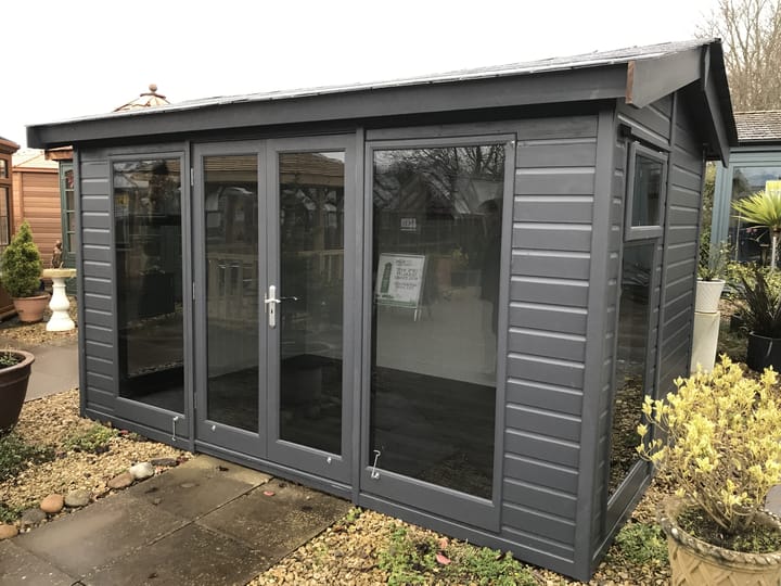 12ft x 8ft Malvern Studio Pavilion painted in Graphite Grey optional painted finish, with optional tinted glass windows, painted mdf lining and insulation, a deluxe laminate floor and slate effect tiled roof.