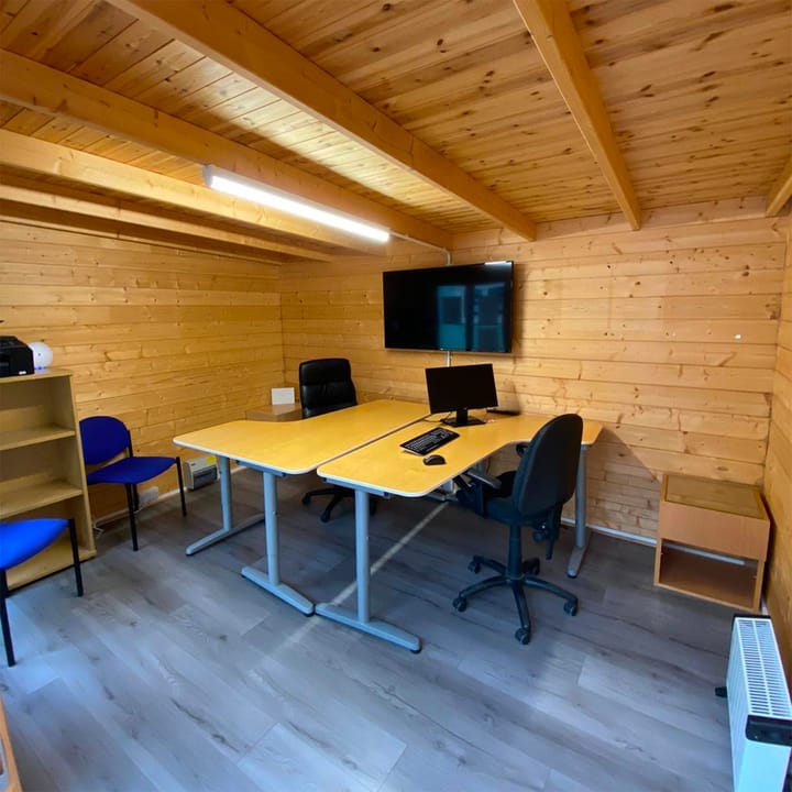 This image showcases a Lillevilla Log Cabin as an exemplary home office, blending rustic charm with modern functionality. Its spacious, well-lit interior provides a serene, productive workspace, demonstrating the cabin's versatility and efficiency